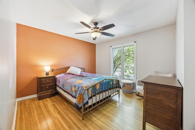 bedroom featuring light wood-style flooring, baseboards, and ceiling fan