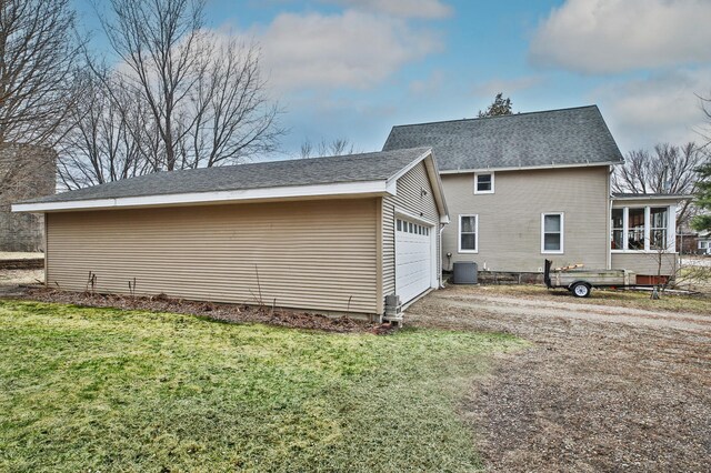 29058 132nd St, Waseca, MN 56093 - view of home's exterior featuring a lawn, a sunroom, driveway, and an attached garage