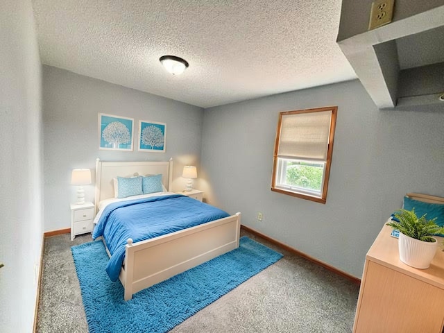 carpeted bedroom featuring a textured ceiling and baseboards