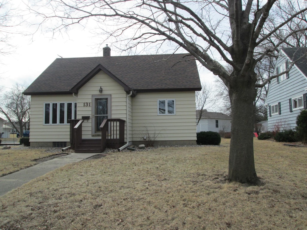 131 4th St, Kenyon, MN 55946 - view of front facade with a chimney, a front lawn, and roof with shingles