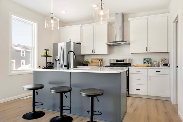 11525 202nd St W, Lakeville, MN 55044 - kitchen with appliances with stainless steel finishes, white cabinetry, a kitchen breakfast bar, wall chimney exhaust hood, and tasteful backsplash