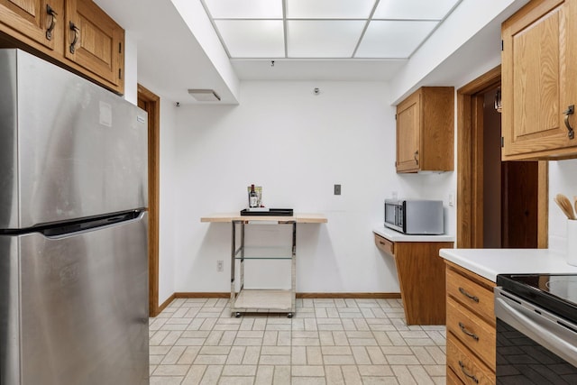 1235 Yale Pl Unit 207, Minneapolis, MN 55403 - kitchen with brown cabinets, light countertops, brick patterned floor, stainless steel appliances, and baseboards