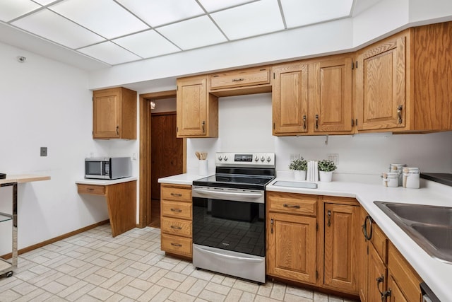 1235 Yale Pl Unit 207, Minneapolis, MN 55403 - kitchen with brown cabinets, light countertops, baseboards, brick patterned floor, and stainless steel appliances