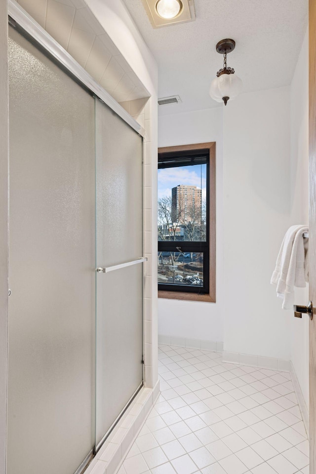 1235 Yale Pl Unit 207, Minneapolis, MN 55403 - bathroom featuring baseboards, visible vents, tile patterned flooring, and a stall shower