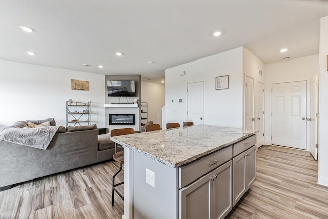 6432 Genevieve Trl S, Cottage Grove, MN 55016 - kitchen featuring gray cabinets, a kitchen island, light wood-type flooring, open floor plan, and a breakfast bar