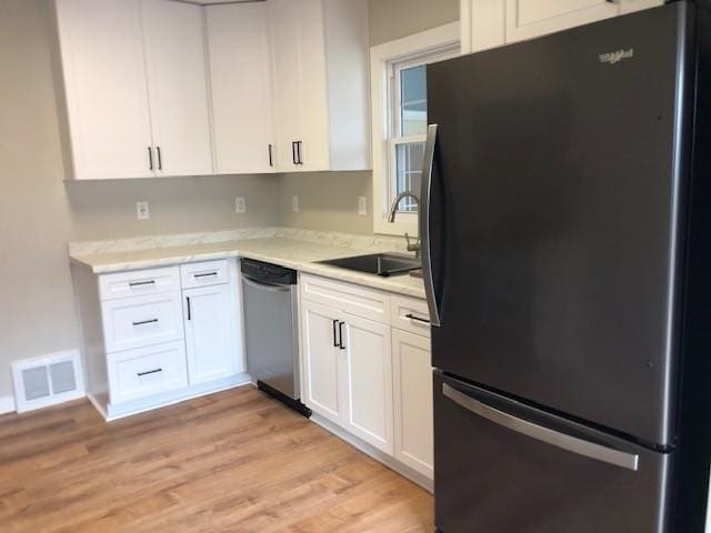 207 Astro Blvd W, Cosmos, MN 56228 - kitchen featuring light countertops, visible vents, dishwasher, a sink, and freestanding refrigerator
