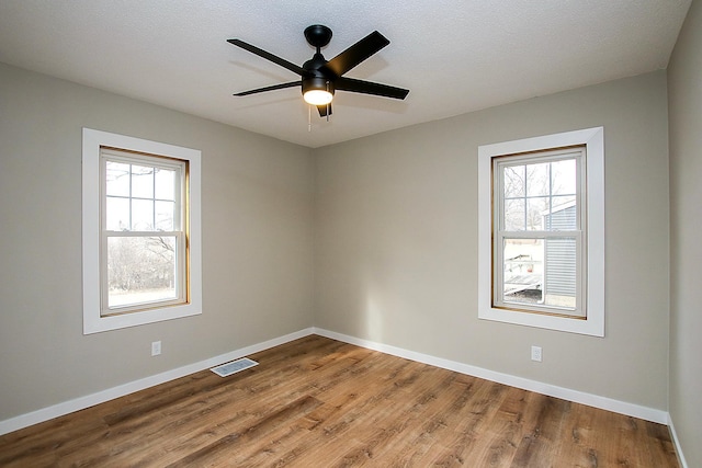 207 Astro Blvd W, Cosmos, MN 56228 - spare room featuring wood finished floors, plenty of natural light, baseboards, and visible vents