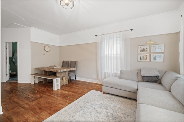 living area with baseboards, wood finished floors, and ornamental molding