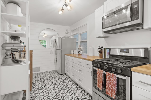 kitchen with visible vents, white cabinets, stainless steel appliances, wood counters, and open shelves