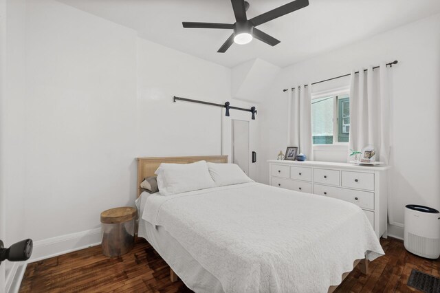 bedroom with dark wood finished floors, a ceiling fan, and baseboards