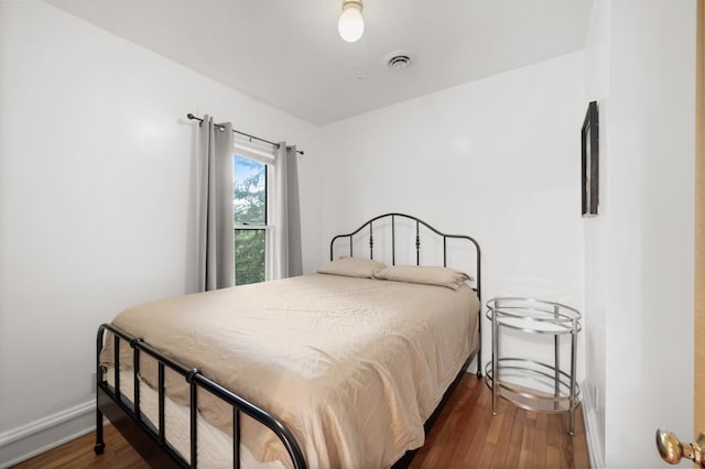 bedroom featuring visible vents, baseboards, and dark wood-type flooring