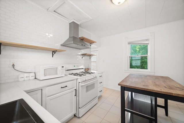 kitchen featuring white appliances, light countertops, wall chimney range hood, and open shelves