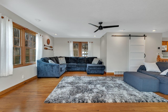 616 Lake Cowdry Rd NW, Alexandria, MN 56308 - living room with a barn door, ceiling fan, wood finished floors, and recessed lighting
