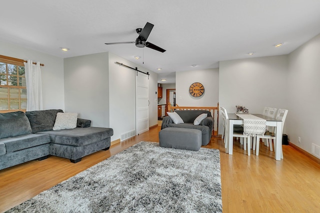 616 Lake Cowdry Rd NW, Alexandria, MN 56308 - living area with a barn door, light wood finished floors, a ceiling fan, and recessed lighting