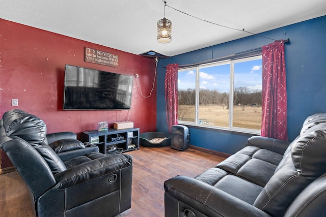 living area with baseboards and wood finished floors