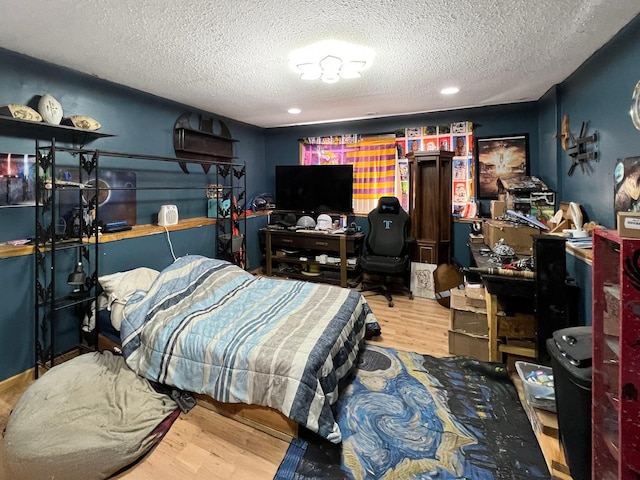 bedroom featuring a textured ceiling, recessed lighting, and wood finished floors