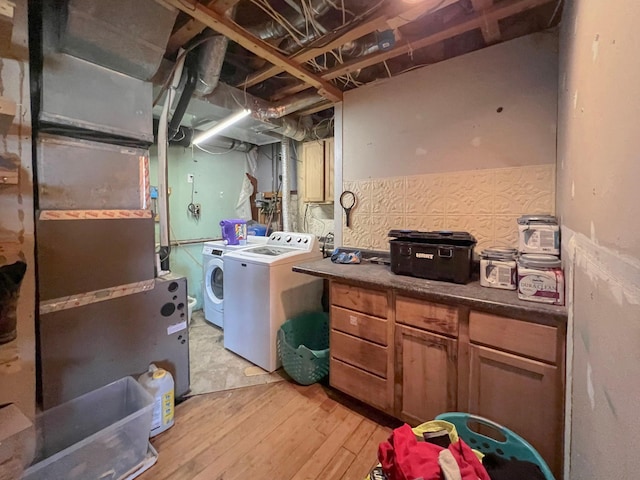 clothes washing area with laundry area, light wood finished floors, and independent washer and dryer