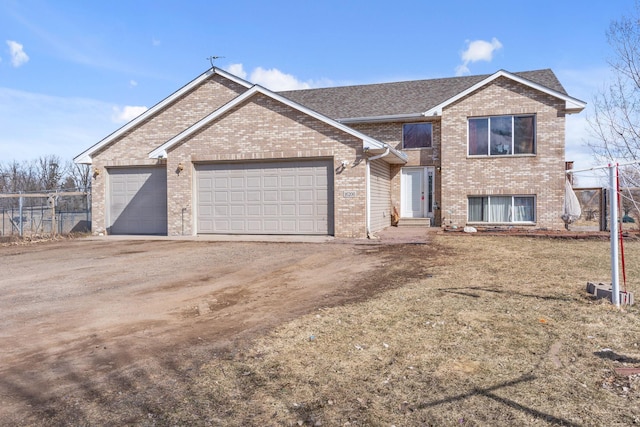view of front facade featuring brick siding, an attached garage, fence, and dirt driveway