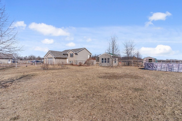 view of yard featuring fence and an outbuilding
