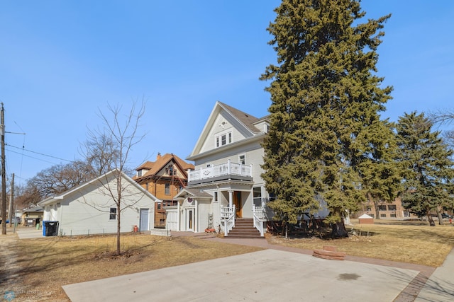 view of front facade featuring a balcony and a front lawn