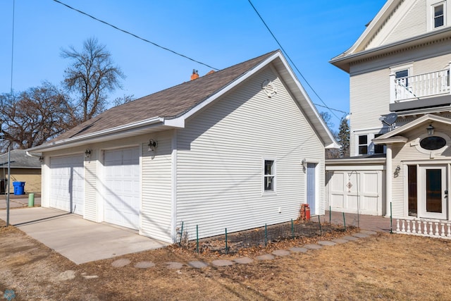 view of home's exterior with a detached garage and fence