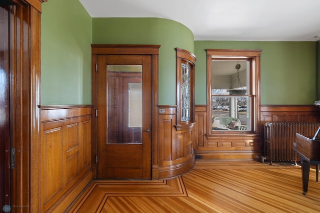 interior space featuring radiator heating unit and wainscoting