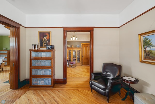 living area featuring light wood-style flooring and a notable chandelier