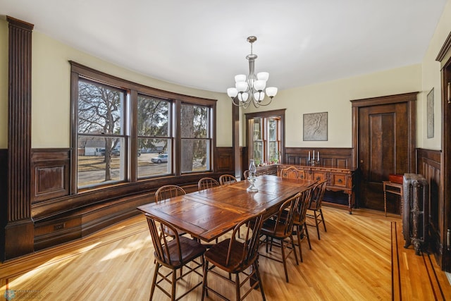 dining room featuring wainscoting, a notable chandelier, and radiator heating unit