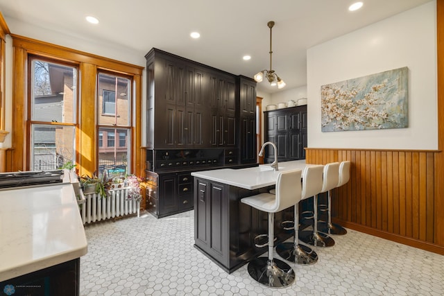 bar with a wainscoted wall, wooden walls, recessed lighting, and pendant lighting