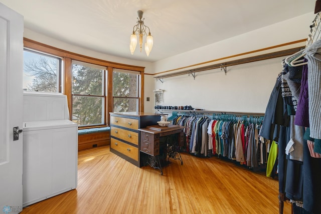 walk in closet featuring an inviting chandelier and light wood-type flooring