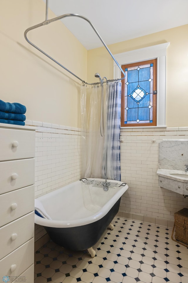 full bathroom with a freestanding bath, curtained shower, tile walls, and wainscoting