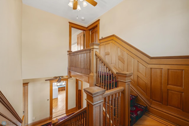 stairs with a ceiling fan and wood finished floors