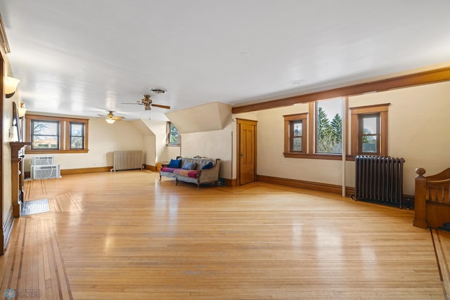 living room with light wood finished floors, radiator, visible vents, and ceiling fan