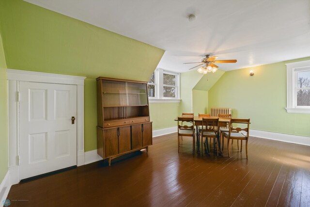 dining space with a wealth of natural light, vaulted ceiling, and dark wood-type flooring