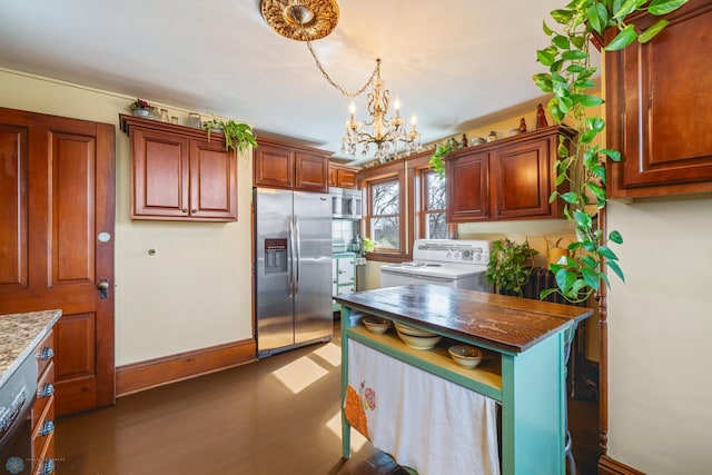 kitchen featuring stainless steel appliances, dark stone countertops, baseboards, a chandelier, and pendant lighting