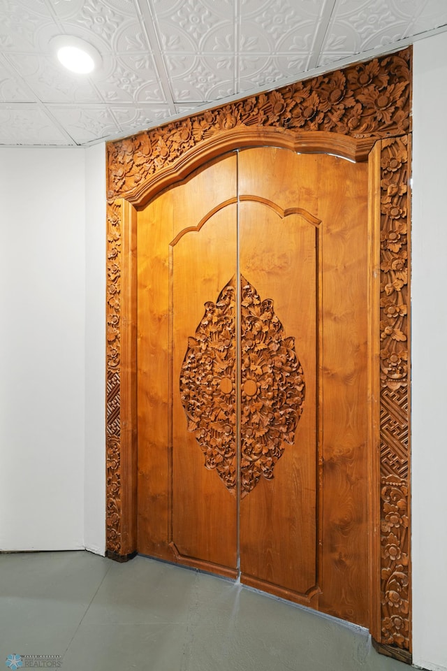 room details featuring an ornate ceiling and concrete flooring