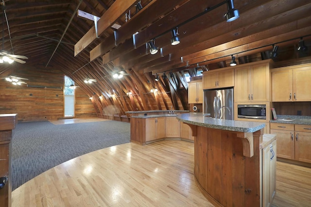 8651 Basswood Rd Unit 203, Eden Prairie, MN 55344 - kitchen with lofted ceiling with beams, open floor plan, stainless steel appliances, wooden walls, and light wood finished floors