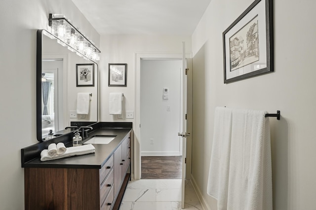 27901 Teale Ave, New Prague, MN 56071 - bathroom with marble look tiles, vanity, and baseboards