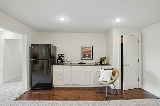 27901 Teale Ave, New Prague, MN 56071 - kitchen with freestanding refrigerator, dark countertops, baseboards, white cabinets, and a sink