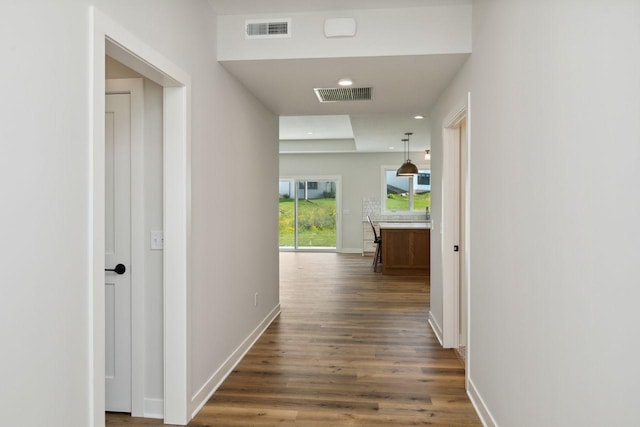 hallway featuring dark wood-style flooring, recessed lighting, baseboards, and visible vents