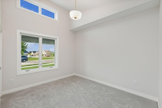 carpeted empty room featuring baseboards