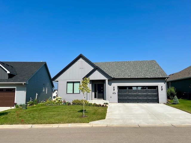modern inspired farmhouse with driveway, an attached garage, a front lawn, and board and batten siding