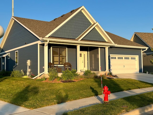 craftsman-style home with a front yard, a porch, concrete driveway, and an attached garage