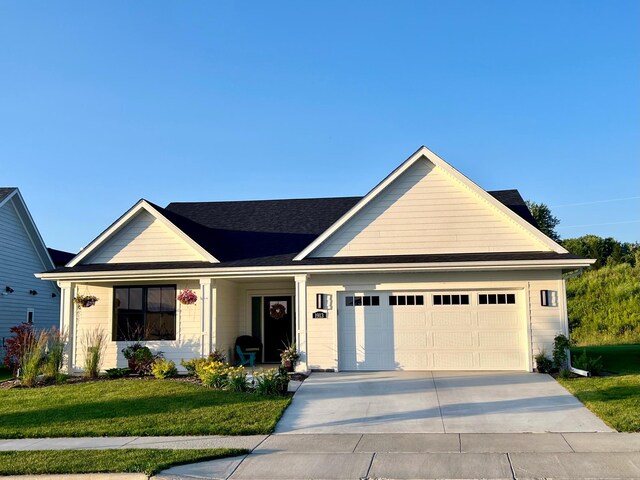 ranch-style home featuring a garage, concrete driveway, a porch, and a front yard