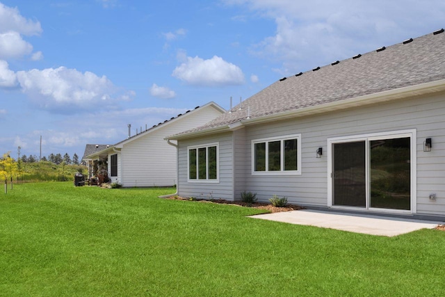 back of property featuring a patio area and a lawn