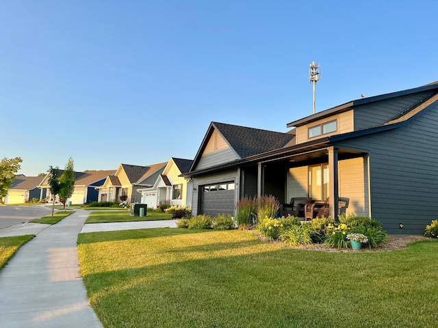 view of front of house featuring a residential view, a front yard, concrete driveway, and a garage