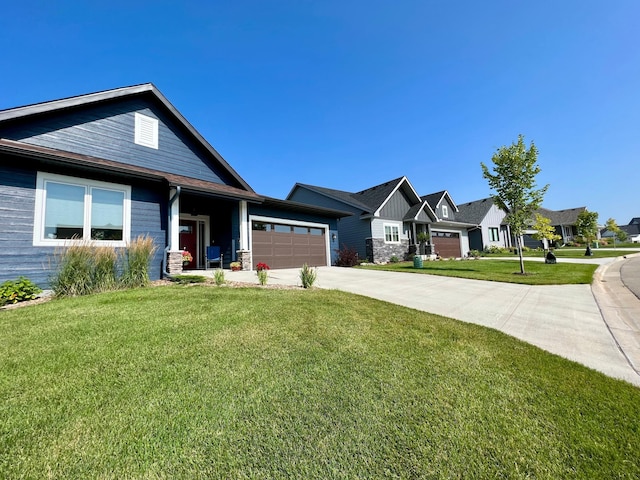 view of front of house with driveway, a garage, a front lawn, and a residential view