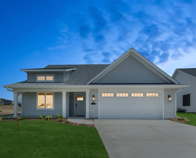 view of front of property with a shingled roof, driveway, a front lawn, and an attached garage
