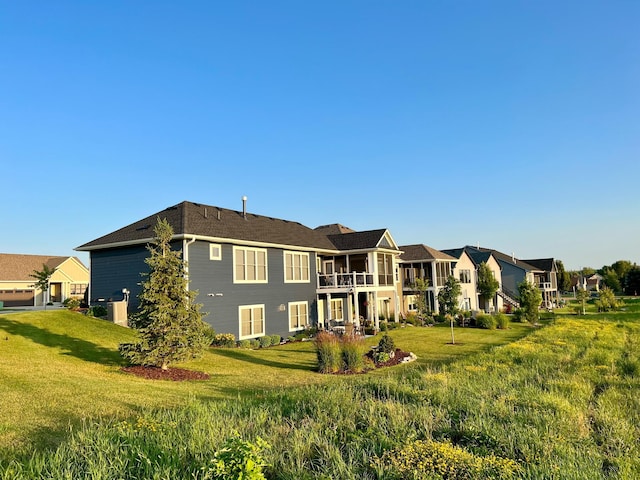 rear view of house with a residential view and a yard