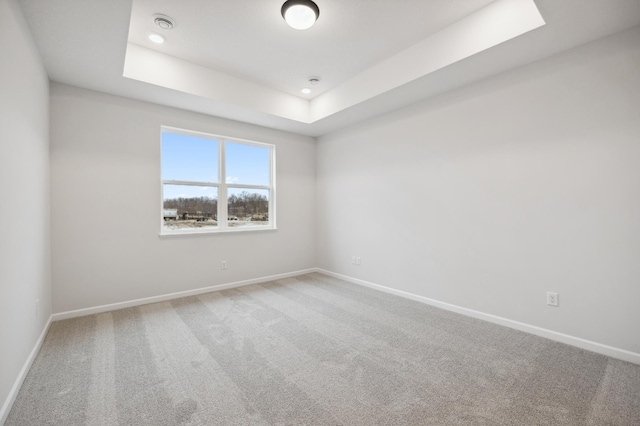 unfurnished room featuring a raised ceiling, baseboards, recessed lighting, and carpet floors